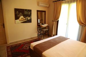 a bedroom with a bed and a table and a window at Dardanos Hotel in Patara