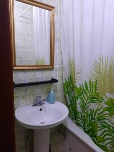a bathroom with a sink and a shower curtain at Квартира возле оперного театра 22 in Almaty