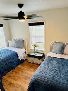 a bedroom with two beds and a ceiling fan at Farm Charm 