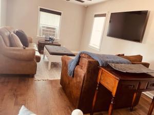 a living room with a couch and a flat screen tv at Farm Charm in Iowa Park