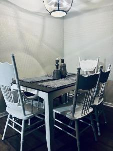 stół jadalny z 4 krzesłami, stołem i lampką w obiekcie Farm Charm 