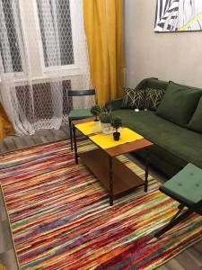 a living room with a green couch and a coffee table at Квартира возле оперного театра 22 in Almaty