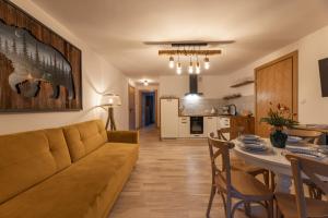 a living room and kitchen with a couch and a table at Anielski Zakątek Solina - balia z jacuzzi i sauna w cenie pobytu in Solina