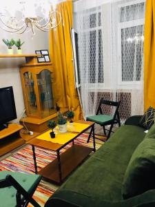 uma sala de estar com um sofá e uma mesa em Квартира возле оперного театра 22 em Almaty