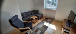 uma sala de estar com um sofá e uma televisão em Ferienwohnung Gasthof Port em Naunheim