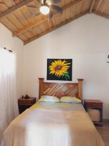 1 dormitorio con 1 cama grande con una pintura floral en la pared en Villas Montelindo, en Constanza