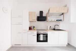eine weiße Küche mit weißen Schränken und einer Spüle in der Unterkunft Charming Apartment near Center in Wien