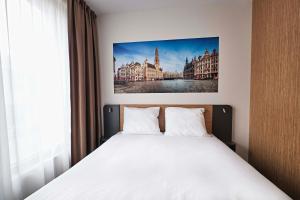 a bedroom with a bed with a picture on the wall at easyHotel Brussels City Centre in Brussels