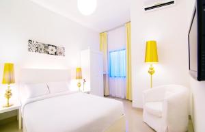 1 dormitorio blanco con 1 cama blanca y 1 silla blanca en Chulia Heritage Hotel, en George Town