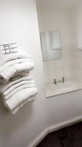 Hotels 24-7 - The Old Victoria Hotel في نيوبورت: حمام أبيض مع حوض ومناشف بيضاء