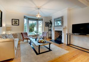 a living room with a table and a fireplace at Waters Reach in Fowey