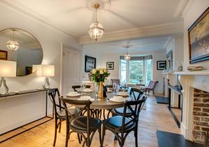 a dining room with a table and chairs and a fireplace at Waters Reach in Fowey