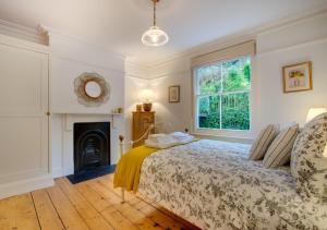 a bedroom with a bed and a fireplace at Waters Reach in Fowey