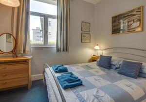 a bedroom with a bed with blue towels on it at Sundowner in Saint Levan