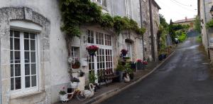 La Belle Maison في Piégut-Pluviers: زقاق مع الزهور على جانب المبنى