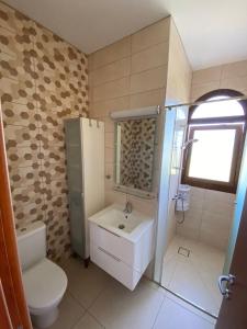 y baño con aseo blanco y lavamanos. en Villa Angel - Exotic Villa 200m From Beach en Paralimni