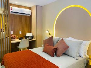 um quarto com uma cama grande com almofadas e uma secretária em Flat Beach Class Executive - Beira Mar de Boa Viagem em Recife