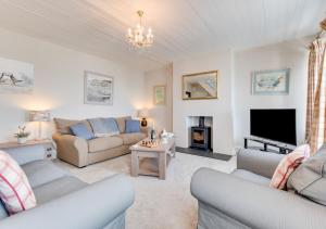 a living room with two couches and a tv at Uplands in Praa Sands