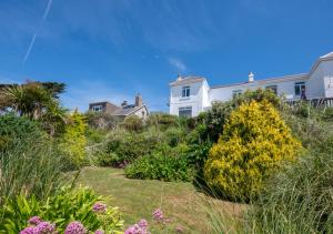a garden with flowers and houses in the background at Uplands in Praa Sands