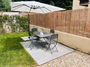 uma mesa e cadeiras com um guarda-sol num quintal em Appartamento 109 con giardino esclusivo em Lucca