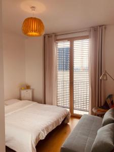 - une chambre avec un lit et une grande fenêtre dans l'établissement Appartement T3 Confluence, à Lyon