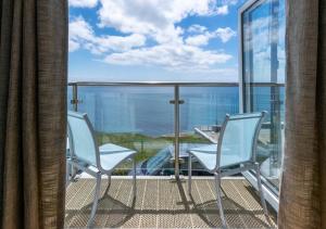 two chairs on a balcony with a view of the ocean at Neptune House in Porthleven
