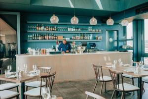 a man standing at the counter of a restaurant at Menlyn Maine Trilogy Apartment 509 in Pretoria