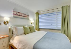 a bedroom with a large bed and a window at Neptune House in Porthleven