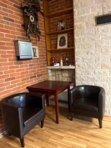 斯巴拉的住宿－Dom z Ogrodem w Spale，一间带桌子和两把黑色椅子的用餐室