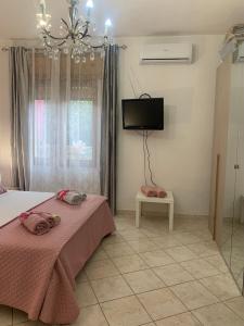 a bedroom with two beds and a flat screen tv at Butterfly House in Villaputzu