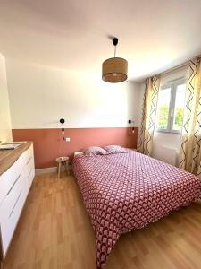 レ・サ​​ーブル・ドロンヌにあるLa Maison Cilaos - Proche merのベッドルーム1室(大型ベッド1台、赤い掛け布団付)