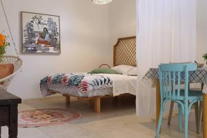 Un dormitorio con una cama y una silla azul. en נקודת חן, en Shadmot Devora 13 fotos más