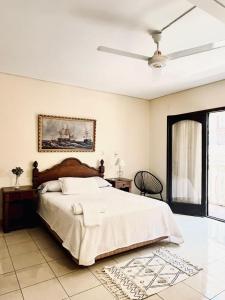 a bedroom with a large bed and a ceiling fan at Hotel Renacer Tarija in Tarija