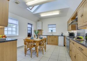 a large kitchen with a wooden table and chairs at Auntie Katies Cottage in Looe