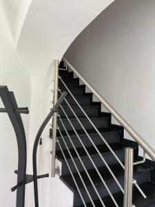 a staircase with black treads and a metal railing at Ferienwohnung Igerc in Feistritz ob Bleiburg