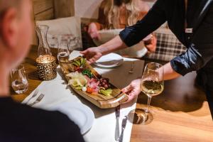 un grupo de personas sentadas en una mesa con un plato de comida en Aktiv Hotel & Spa Hannigalp en Grächen