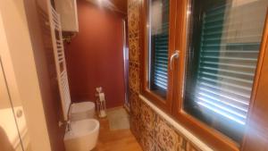 a bathroom with a toilet and a window and a sink at CASA DI EDWYN in Lerici