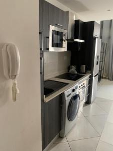 een keuken met een magnetron en een wasmachine bij Prinarks luxury Apartment in Accra