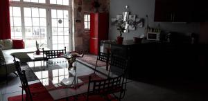 uma sala de estar com uma mesa de vidro e cadeiras em La Belle Maison em Piégut-Pluviers
