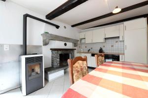 a kitchen with a fireplace and a table and chairs at Centovalli & Nature in Palagnedra