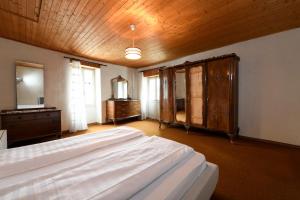 1 dormitorio con cama, tocador y espejo en Centovalli & Nature, en Palagnedra
