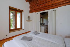 a bedroom with a bed and a window and a bathroom at Palm Cottage in Locarno