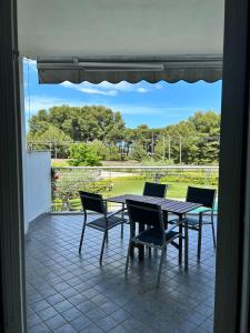 un patio con tavolo e sedie e vista su un campo di Suite Pineto Mare Mykonos Residence a Pineto