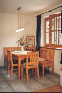 a dining room with a wooden table and chairs at Apartment im Obstgarten in Rottau