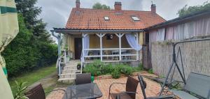 a house with a patio with chairs in front of it at Apartment Balatonfenyves/Balaton 26709 in Balatonfenyves