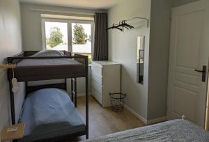 1 dormitorio con 2 literas y ventana en comme à la maison, en Clonas-sur-Varèze