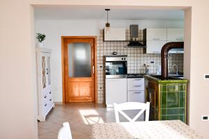 cocina con armarios blancos y puerta de madera en Apartment Laetitia, en Kaštelir