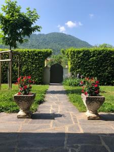 two vases with red flowers on a walkway at The Lake Garden 1 in Caslano