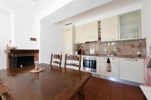 a kitchen with white cabinets and a wooden table at The Lake Garden 1 in Caslano