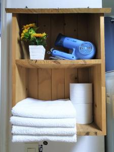a wooden shelf with towels and a blue object on it at Ewha Hostel in Seoul